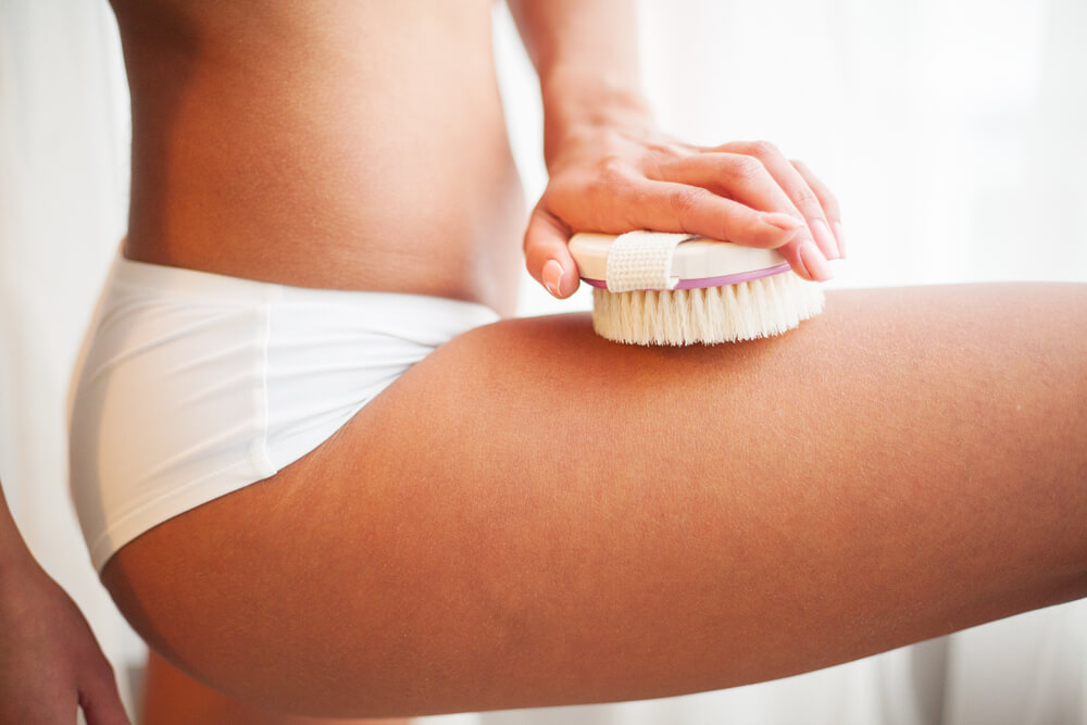 Woman dry brushing leg