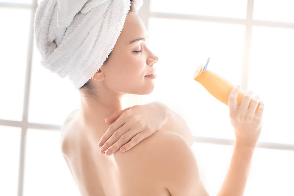 Woman applying body lotion