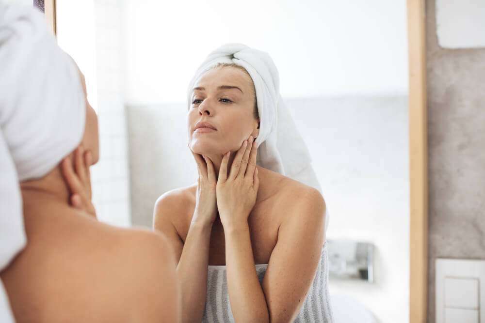 Woman touching crepey neck