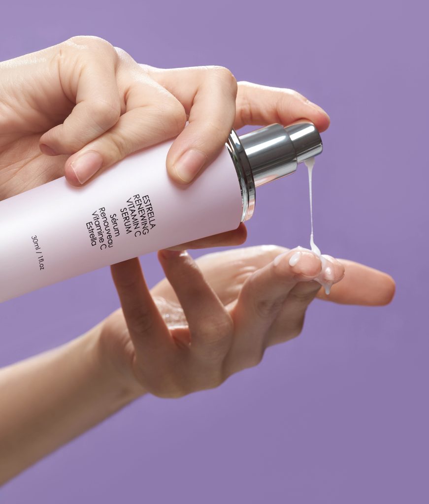 Hand using the Estrella Renewing Vitamin C Serum
