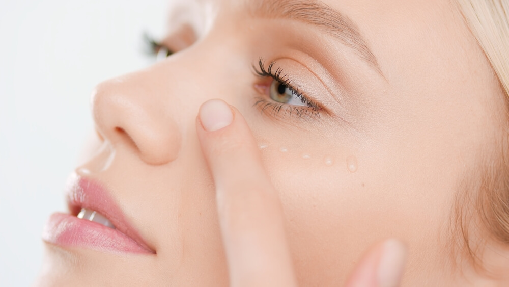 Woman using eye serum