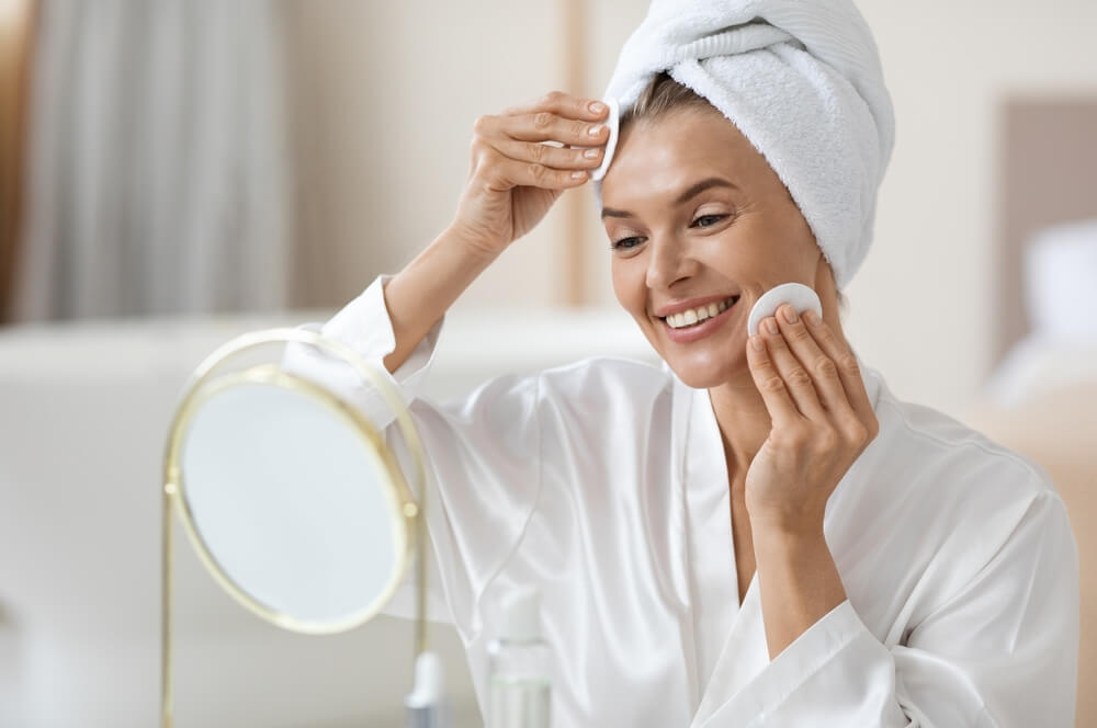 Woman looking at skin in mirror