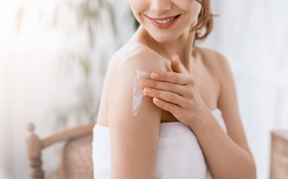 Woman applying cream to arm