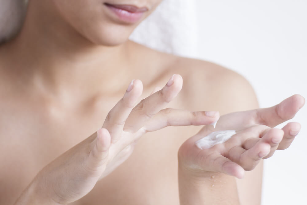 Woman with moisturizer on hand