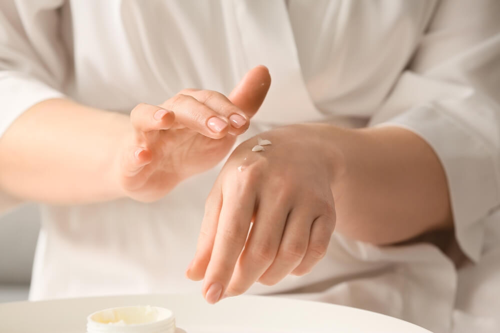 Woman showing the top 5 benefits of body butter by applying some to her hand