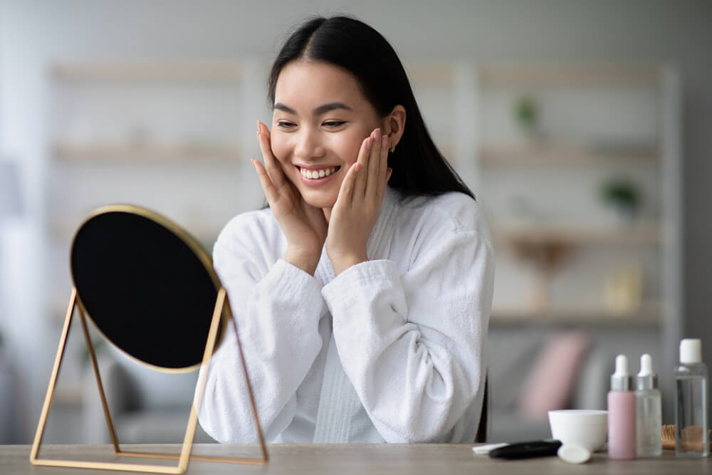 Woman looking at skin in mirror