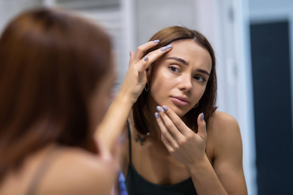 Woman looking at face after using Celestolite serum