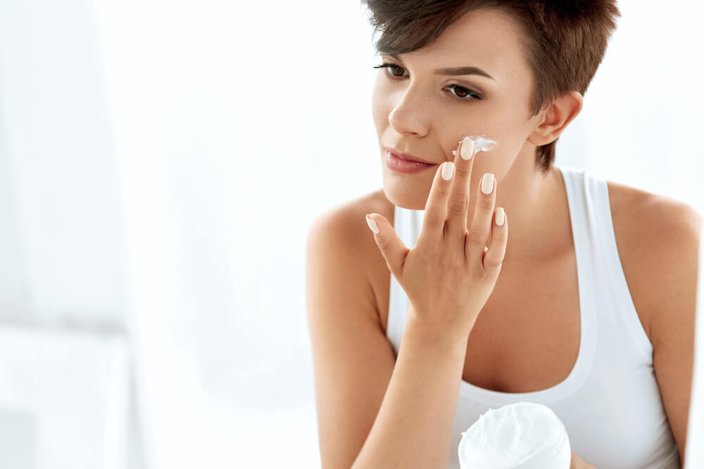 woman applying moisturizer