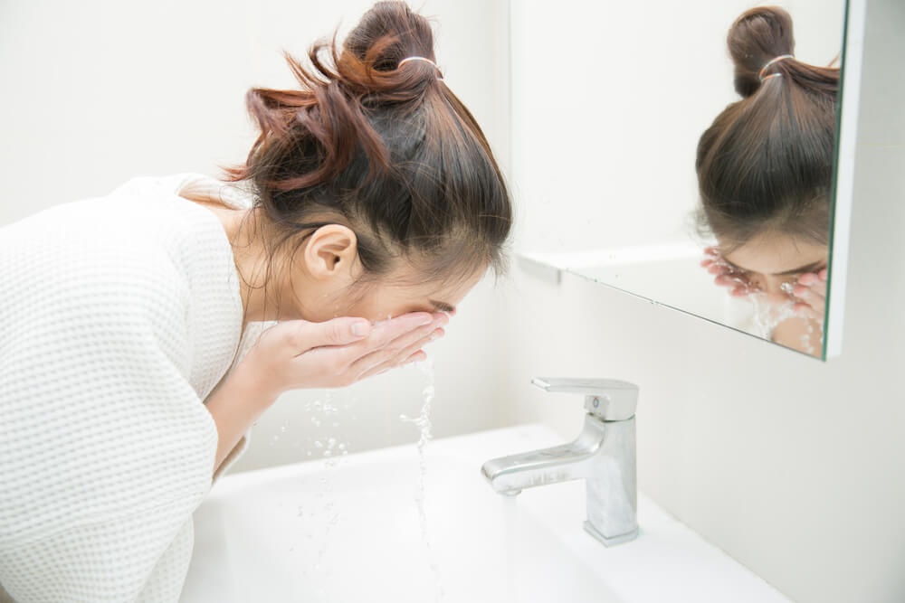 woman rinsing face