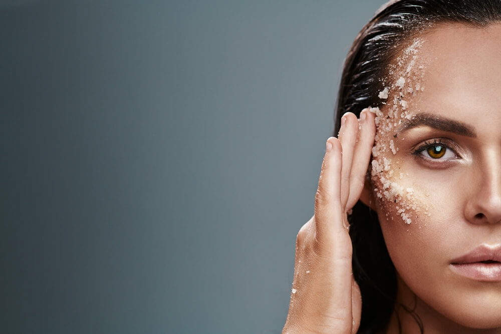 woman exfoliating face