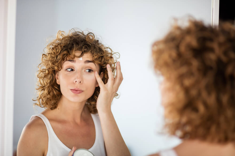 woman applying moisturizer